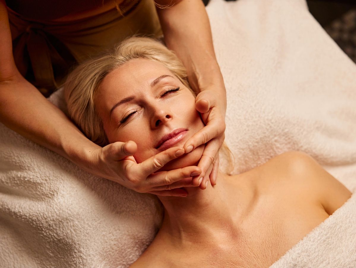 Facial Treatments Miami. A woman receives a relaxing facial massage in a spa setting.